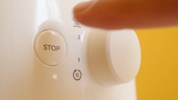 Stop button pressing on two-slot automatic electric toaster slow-mo footage