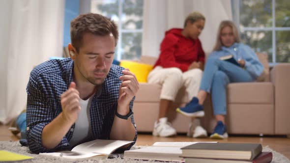 Handsome Student in Wireless Earphones Listening To Music and Relaxing During Break From Study