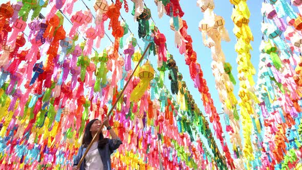 A portrait of Asian woman with colorful lanterns or lamps during travel trip and holidays vacation