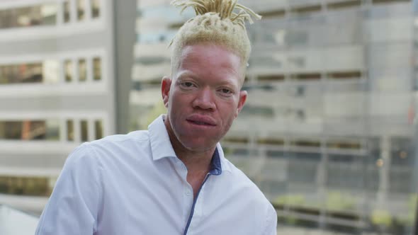 Portrait of happy albino african american businessman in creative office