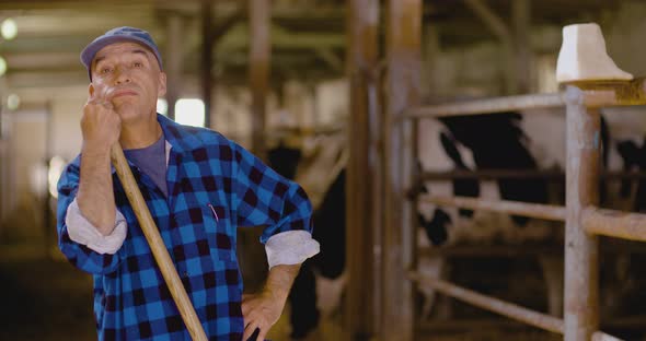 Confident Mature Male Farmer Holding Pitchfork in Stable