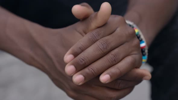 Thoughtful american african young man rubbing his hands - outdoor