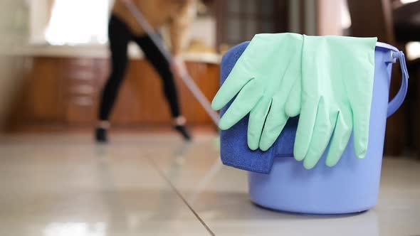 Close-up, home cleaning supplies. Girl dancing while cleaning the house