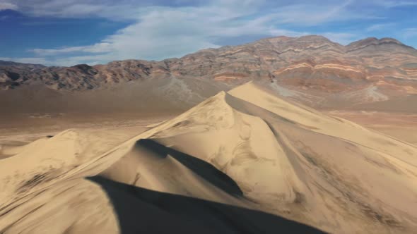 Aerial Speedy Shot Sand Dune Peak with Desert Wilderness on Background at Sunset