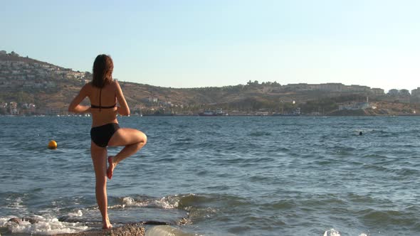 Young Woman Practicing Yoga On The Sea Beach 1