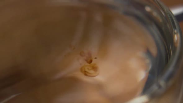 Drops of herbal extract falling from a pipette into a glass of water. Cannabis oil