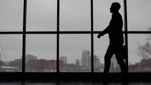 Businessman Goes Near the Window in the Office and Throws Documents Up