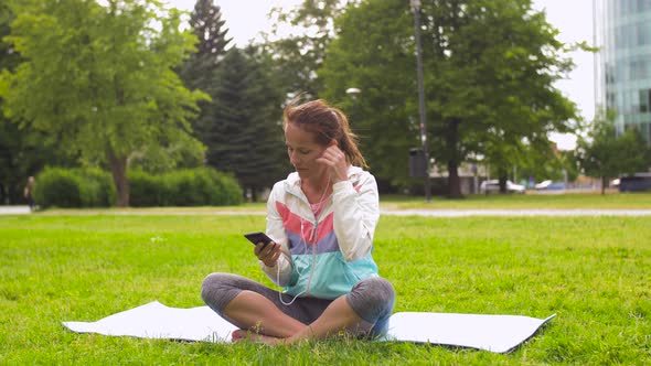 Woman with Smartphone Putting Music for Meditation 75