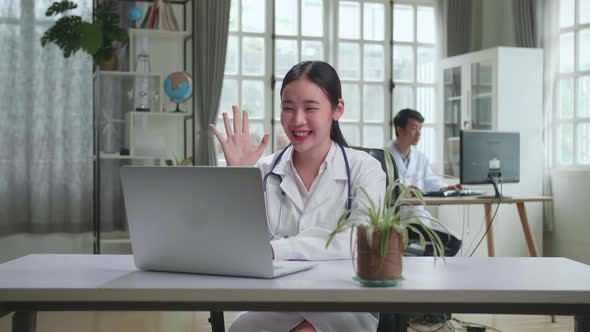 Asian Female Doctor Communicates With Patient By Video Link on Laptop, Doctor Consults Patient