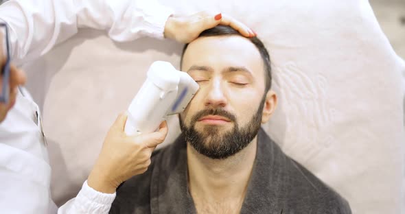 Man on Ultrasound Face Lifting Procedure in Cosmetology Salon