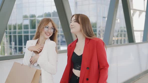 Happy young girls friends with shoping bags, talking and laughing. slow mo steadicam shot