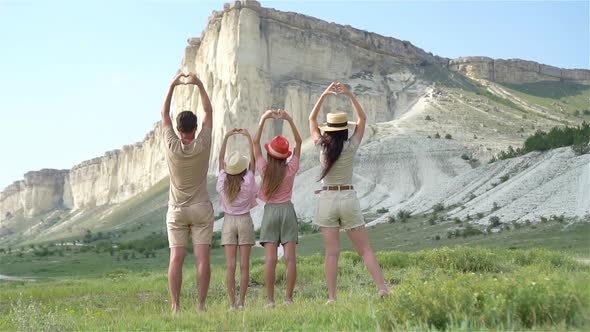 Happy Family of Four Walking in the Mountains