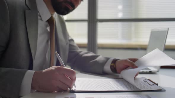 Businessman Signing Agreement and Giving Handshake to Colleague