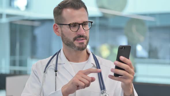 Middle Aged Male Doctor Doing Video Call on Smartphone