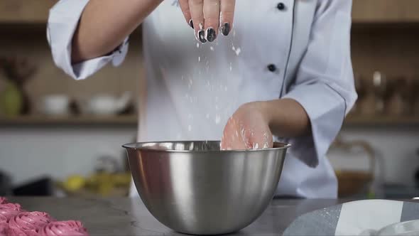 Female Confectioner Throwing Powdered Sugar Into Plate During Cooking Some Cake