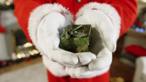 Close-up of santa claus holding a gift box