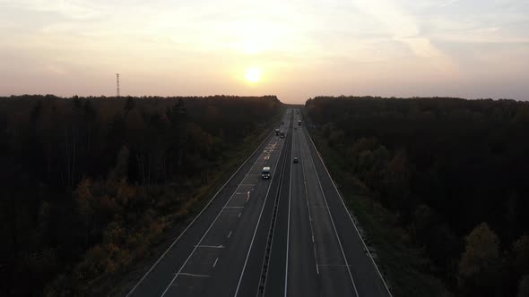 Top View on Trucks and Cars on Asphalt Road at Sunset