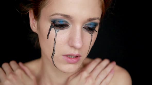 Young Woman Crying on Black Background