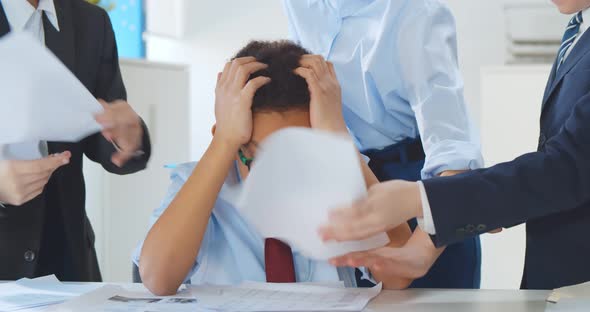 Exhausted Tired Little Businessman Sitting at Desk Colleagues Shaking Papers in Face