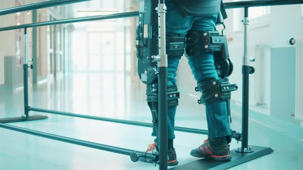 A Person is Training to Walk in the Hospital While Wearing Exoskeleton