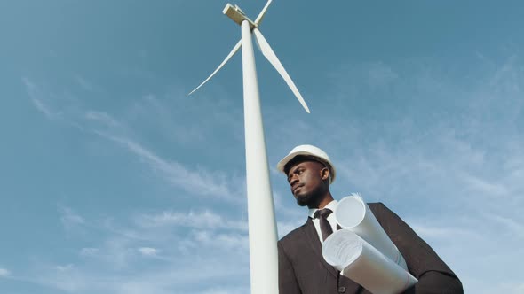 African American Businessman in Black Stylish Suit and White Helmet Holding