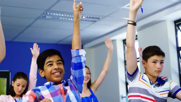 Student raising hand in classroom