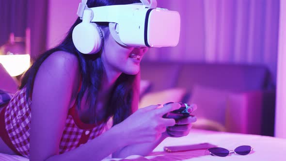 Young asian woman is using virtual reality headset. Neon light