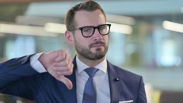 Portrait of Thumbs Down Gesture By Middle Aged Businessman