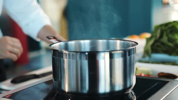 Close-up: The chef adds ingredients to the pot. The process of preparing food in a restaurant.
