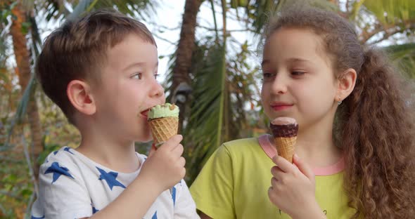 Smiling Children Happy Little Boy and Girl Eating Ice Cream and Having Fun Looking at Each Other