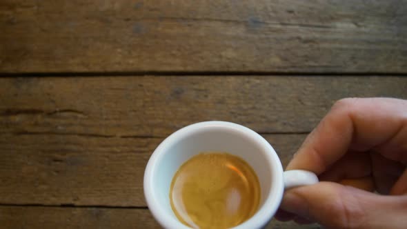 First person perspective of someone drinking from a espresso coffe cup.