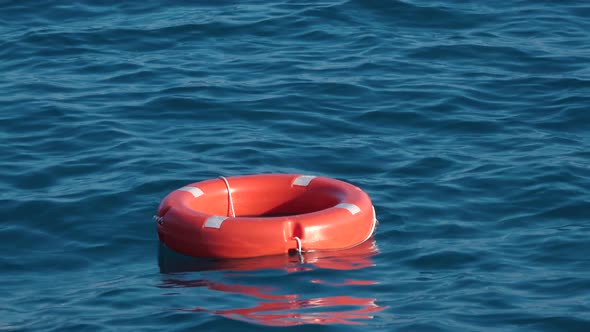 Life Buoy or Rescue Buoy Floating on Sea To Rescue People From Drowning Man.