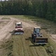 Drone view of tractors tamp the silage in the Silo Trench next to the forest 07 - VideoHive Item for Sale