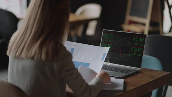 Asian Businesswoman Analyzing a Graphic of a Stock Exchange Chart