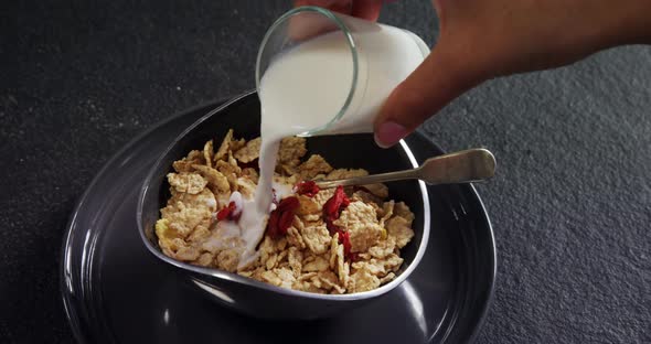 Milk being poured into wheat flakes bowl 4k