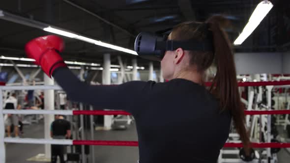 A Young Woman Trains Her Punches Wearing VR Glasses in the Gym  Shadow Boxing