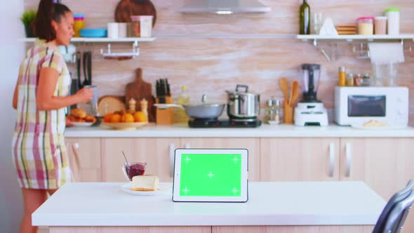 Woman Looking at Tablet Computer with Green Mockup