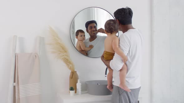 Father with Cute Toddler Brushing Teeth in Morning