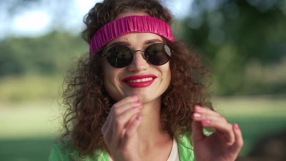 Closeup Face Smiling Caucasian Retro Woman Putting on Sunglasses Looking at Camera