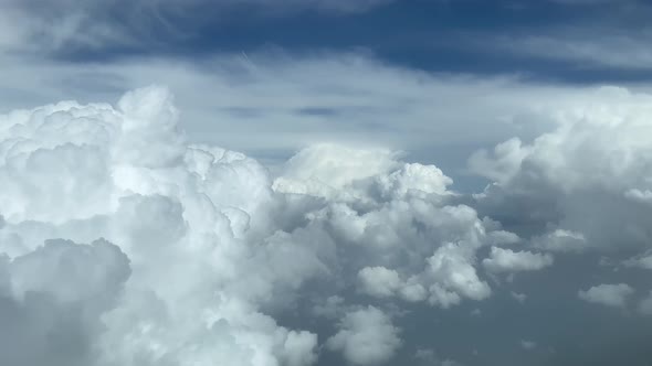 Aerial view from a jet cockpit, pilot POV while flying through a stormy and messy sky with a deep bl