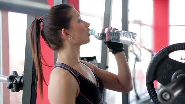 Beautiful Girl Drinking Clear Water After Active Sports Workout at Fitness Club