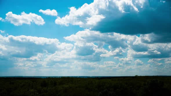 White Fluffy Clouds Slowly Float Through the Blue Daytime Sky Timelapse