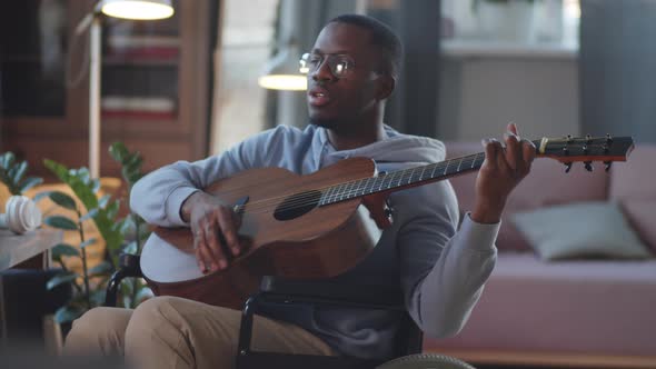 Black Man on Wheelchair Playing the Guitar and Singing