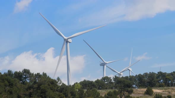 Windmill Farm Wind Electro Eco Energy Turbines on Blue Sky Background on European Pyrenees Mountains