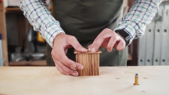 Close Up of Craftsman Hands Sanding the Surface of Handmade Wooden Box with Abrasive Paper Man