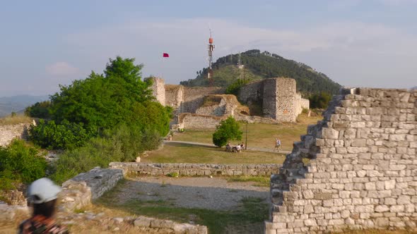 Young traveling couple exploring the ruins of an ancient castle at sunset in Berat, Albania.