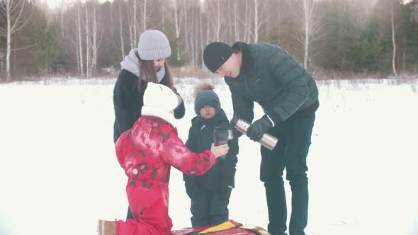 Family Drinking Tea From the Termos Outdoors