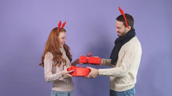 Christmas Gifts. Happy Couple Makes a Surprise Friend Drood, They Give Christmas Gifts in Studio on