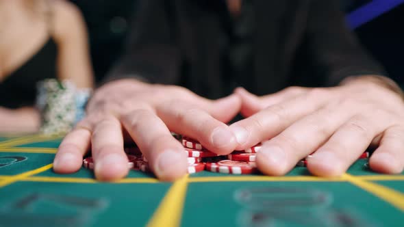 Casino, Gambling, Poker, People and Entertainment Concept - Close Up of Poker Player with Chips at