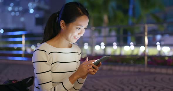 Woman use of smart phone in city at night 